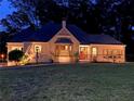 Inviting home exterior at night, showcasing a cozy bay window and warm lighting highlighting the facade at 584 Cherokee Ne St, Marietta, GA 30060