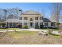 Elegant two-story home boasts a columned facade and circular driveway, enhancing its grand presence and curb appeal at 5430 Burdette Se Rd, Mableton, GA 30126