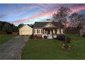 Charming single-Gathering home at dusk with a well-maintained lawn and a detached two-car garage at 363 Safe Harbor Dr, Dallas, GA 30157