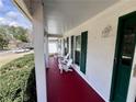 Inviting covered porch featuring comfortable seating, green shutters, and a freshly painted red floor at 3750 Clubhouse Se Ln, Conyers, GA 30094