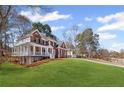 Side view of a beautiful brick home with a large, well-kept lawn and a welcoming front porch at 4140 Hillsborough, Cumming, GA 30041