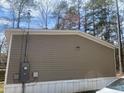 Side view of a tan home, showing the siding and utility connections at 53 Oakview Dr, Carrollton, GA 30116