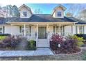 Inviting home with a covered front porch, decorative columns, and manicured landscaping at 684 Oak Moss Dr, Lawrenceville, GA 30043