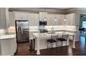 Modern kitchen features white cabinets, stainless steel appliances, and a large center island with seating at 188 Foxtail Rd, Woodstock, GA 30188