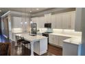 Modern kitchen with white cabinets, stainless steel appliances, quartz countertops, and hardwood floors at 188 Foxtail Rd, Woodstock, GA 30188