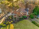 Aerial of a well-maintained home with mature trees, landscaping, and long driveway at 3672 Howell Wood Nw Trl, Duluth, GA 30096