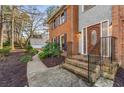 Home's front entrance with brick stairs, black railings, and a wooden front door at 3672 Howell Wood Nw Trl, Duluth, GA 30096