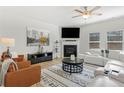 Bright living room boasts neutral paint, fireplace, recessed lighting, and a large white leather sofa at 125 Sunland Blvd, Mcdonough, GA 30253