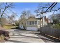 Rear exterior of home with attached garage and sunroom boasting ample natural light at 1989 Mount Vernon Rd, Atlanta, GA 30338