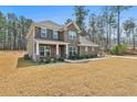Side view of a two-story brick home featuring professionally landscaped front yard at 220 Eastmark Way, Fayetteville, GA 30214