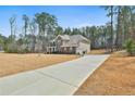 Side view of a two-story brick home featuring a long driveway and attached two-car garage at 220 Eastmark Way, Fayetteville, GA 30214