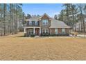 Charming two-story brick home with a covered porch and professionally landscaped front yard at 220 Eastmark Way, Fayetteville, GA 30214