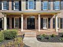 Inviting brick front porch with classic columns and a charming entrance with black shutters at 4312 White Hickory Nw Ln, Kennesaw, GA 30152