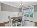 Elegant dining room featuring wainscoting, a modern chandelier, and large windows for natural light at 1803 Stone Bridge Way, Marietta, GA 30064