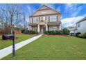 Two-story home boasts beautiful landscaping, green lawn, and inviting walkway to the front door at 1803 Stone Bridge Way, Marietta, GA 30064