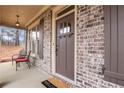 Cozy front porch with brick accents, featuring a stylish door and outdoor seating at 1803 Stone Bridge Way, Marietta, GA 30064