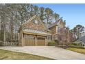 Charming home with a two-car garage and long driveway, complemented by lush landscaping and mature trees at 2290 Dragonfly Nw Ct, Acworth, GA 30101