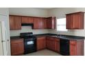 Functional kitchen offering wood cabinets, dark countertops, a black dishwasher, and a range at 2102 Executive Dr, Duluth, GA 30096