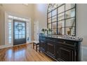 Bright foyer with high ceilings, hardwood floors, and an elegant mirror over a console table at 7085 Wakehurst Pl, Cumming, GA 30040