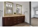 Bathroom features double sinks, granite counters, large mirrors, and dark wood cabinets at 4561 Olde Perimeter Way # 702, Atlanta, GA 30346