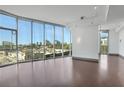 Open living room with hardwood floors and floor to ceiling windows offering abundant light and city views at 4561 Olde Perimeter Way # 702, Atlanta, GA 30346