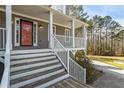Inviting front porch with white railings leading to the home's entrance with stairs at 55 Legend Creek Cove, Douglasville, GA 30134