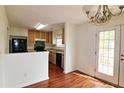 View of kitchen area with wood cabinets, black appliances, and eat-in dining area at 125 Fairhaven Trl, Fairburn, GA 30213