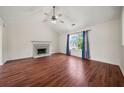 Bright living room featuring hardwood floors, vaulted ceilings, and a cozy fireplace at 125 Fairhaven Trl, Fairburn, GA 30213