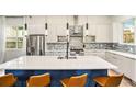Bright kitchen features a central island with seating, stainless steel appliances, and modern white cabinetry at 245 Mathewson Pl, Atlanta, GA 30314