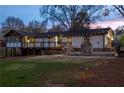 Exterior of the stylish home featuring a stone fireplace, deck, and sunroom in the fenced backyard at 1199 Murray Sw Cir, Marietta, GA 30064