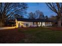 Charming white brick home featuring a well-maintained lawn and string lights in the evening at 1199 Murray Sw Cir, Marietta, GA 30064