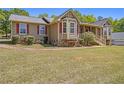 Charming single-story home featuring stone accents, red shutters, bay windows, and a welcoming front porch at 100 Walnut Ct, Stockbridge, GA 30281