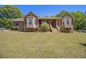 Charming single-story home featuring stone accents, red shutters, bay windows, and a welcoming front porch at 100 Walnut Ct, Stockbridge, GA 30281