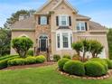 Attractive home showcasing a stone accent wall, a manicured lawn, and decorative front yard shrubbery at 3640 Ridgeway Ter, Suwanee, GA 30024