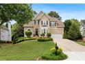 Beautiful two-story home with stone accents, complemented by lush greenery and a well-maintained lawn at 3640 Ridgeway Ter, Suwanee, GA 30024