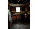 Interior shot of the kitchen with damaged wood cabinets and flooring at 1581 Se Woodland Se Cir, Atlanta, GA 30316