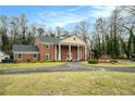 Traditional two-story brick home featuring a circular driveway and well-maintained landscaping at 3074 Cascade Sw Rd, Atlanta, GA 30311