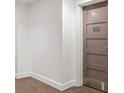 Hallway with neutral carpet, white walls, and a brown condo unit door marked 