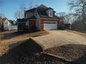 Attached garage with wide driveway and partial view of the backyard and landscaping at 5700 Thrasher Ln, Conyers, GA 30094