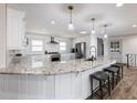 Modern kitchen features a spacious island, granite countertops and stainless steel appliances at 6041 Blackberry Ln, Buford, GA 30518