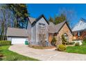 Inviting two-story home boasting stone accents, gray siding, and a well-maintained lawn leading to a garage at 7445 Talbot Colony, Atlanta, GA 30328