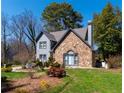 Beautiful two-story home featuring a stone facade, gray siding, and a well-landscaped front yard with mature trees at 7445 Talbot Colony, Atlanta, GA 30328