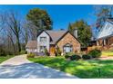 Attractive two-story home with stone and gray siding, complemented by a lush green lawn and mature trees at 7445 Talbot Colony, Atlanta, GA 30328