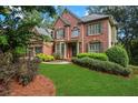 Beautiful brick home with lush landscaping and a well-maintained lawn, situated in a serene and desirable neighborhood at 5425 Edinbourgh Ct, Cumming, GA 30040