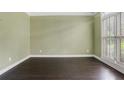 Spacious living room features dark hardwood floors, light green walls, white trim, and large windows with plantation shutters at 5425 Edinbourgh Ct, Cumming, GA 30040