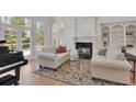 Comfortable living room with a fireplace, piano, and view of the outside through large glass doors at 1112 Kensington Ct, Johns Creek, GA 30022