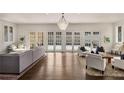 Bright living room boasts hardwood floors, elegant chandelier, and French doors to outdoors at 591 E Morningside Ne Dr, Atlanta, GA 30324