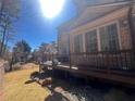 A spacious backyard features a brick home with a wooden deck and an expansive lawn, perfect for outdoor enjoyment at 7920 Georgetown Cir, Suwanee, GA 30024