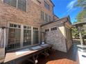 This brick patio has a wooden deck, with a wooden table set for dining and a set of patio heaters at 7920 Georgetown Cir, Suwanee, GA 30024
