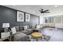 Relax in this modern living room featuring a gray sofa, plush rug, and natural light from the large window at 215 Piedmont Ne Ave # 2201, Atlanta, GA 30308